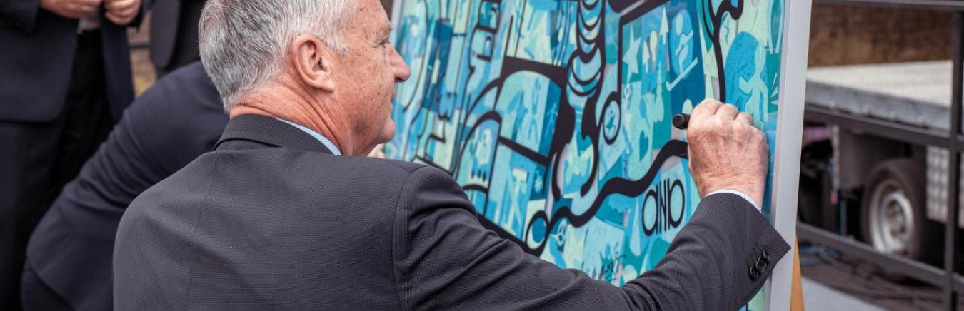 Gratien Maire signant le panneau destinée à la fondation IPS.